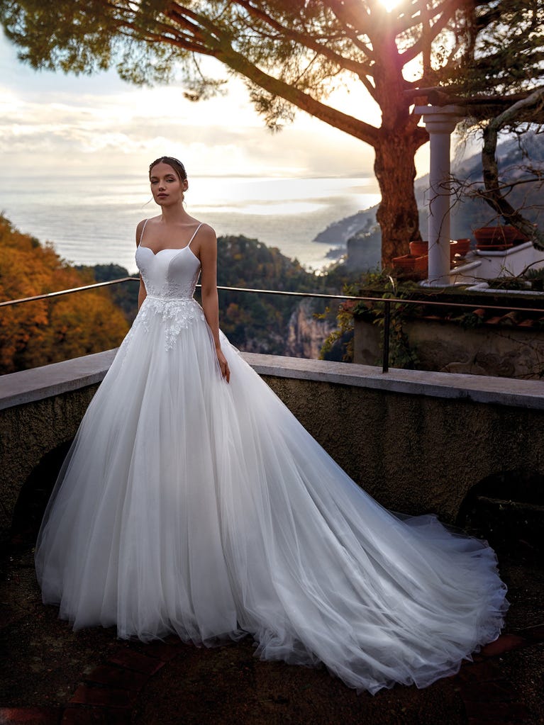 Tulle wedding dress with sleeveless bodice and sweetheart neckline. The embroidered lace creates a fabulous 3D effect, and the removable sleeves will look perfect during the ceremony.