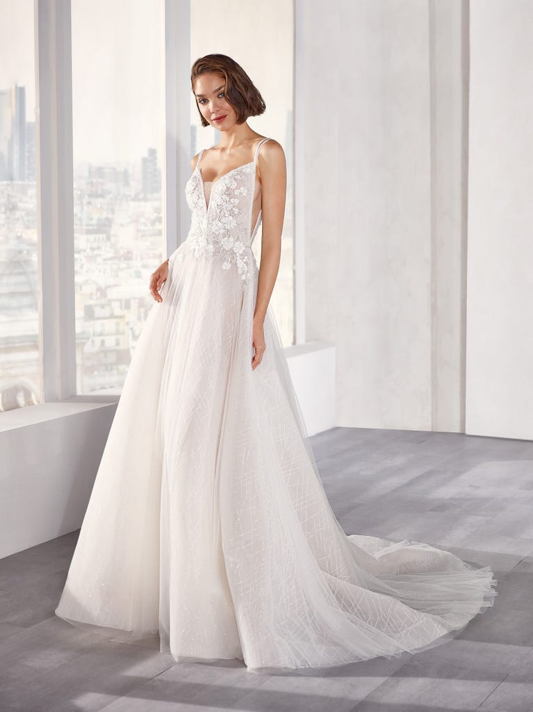 Tulle wedding dress with sleeveless bodice and sweetheart neckline. The embroidered lace creates a fabulous 3D effect, and the removable sleeves will look perfect during the ceremony.