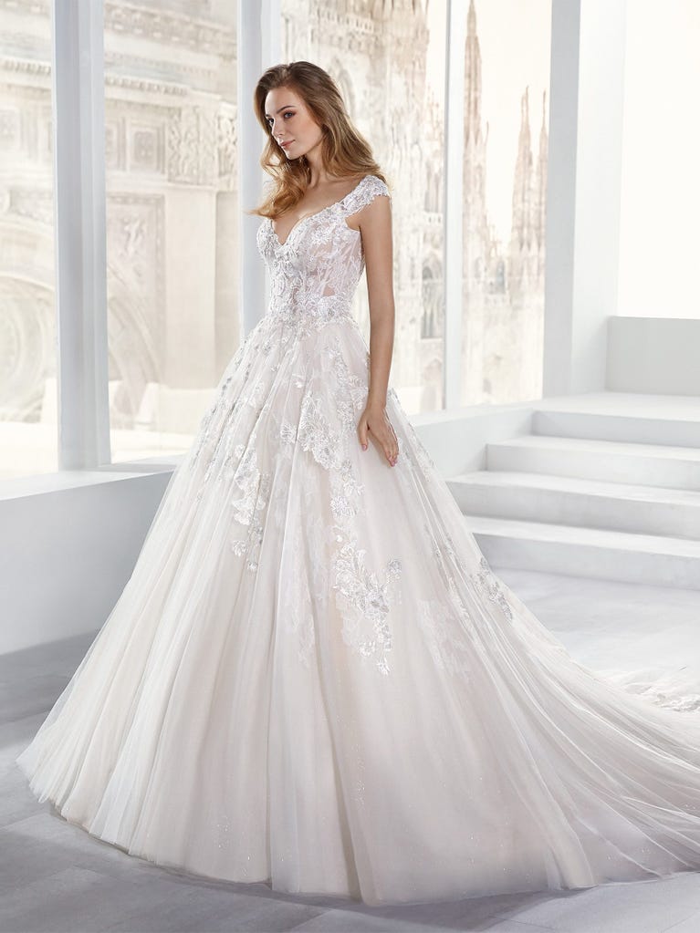 Tulle wedding dress with sleeveless bodice and sweetheart neckline. The embroidered lace creates a fabulous 3D effect, and the removable sleeves will look perfect during the ceremony.