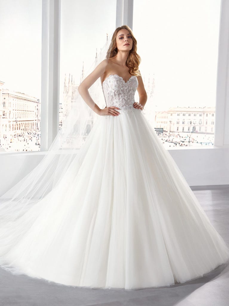 Tulle wedding dress with sleeveless bodice and sweetheart neckline. The embroidered lace creates a fabulous 3D effect, and the removable sleeves will look perfect during the ceremony.