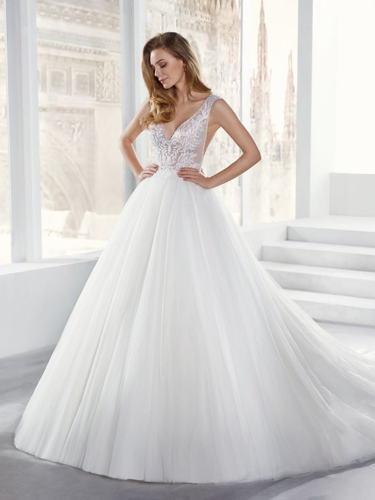 Tulle wedding dress with sleeveless bodice and sweetheart neckline. The embroidered lace creates a fabulous 3D effect, and the removable sleeves will look perfect during the ceremony.