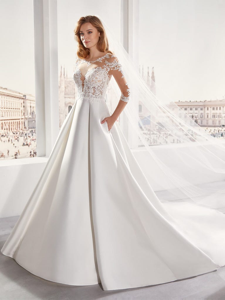 Tulle wedding dress with sleeveless bodice and sweetheart neckline. The embroidered lace creates a fabulous 3D effect, and the removable sleeves will look perfect during the ceremony.