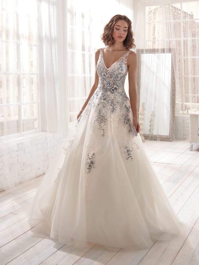 Romantic mermaid wedding dress of light pink Chantilly lace with plunging V-neck that continues on the sleeves. The keyhole opening in back and the tulle overskirt add romanticism to this dreamy dress.
