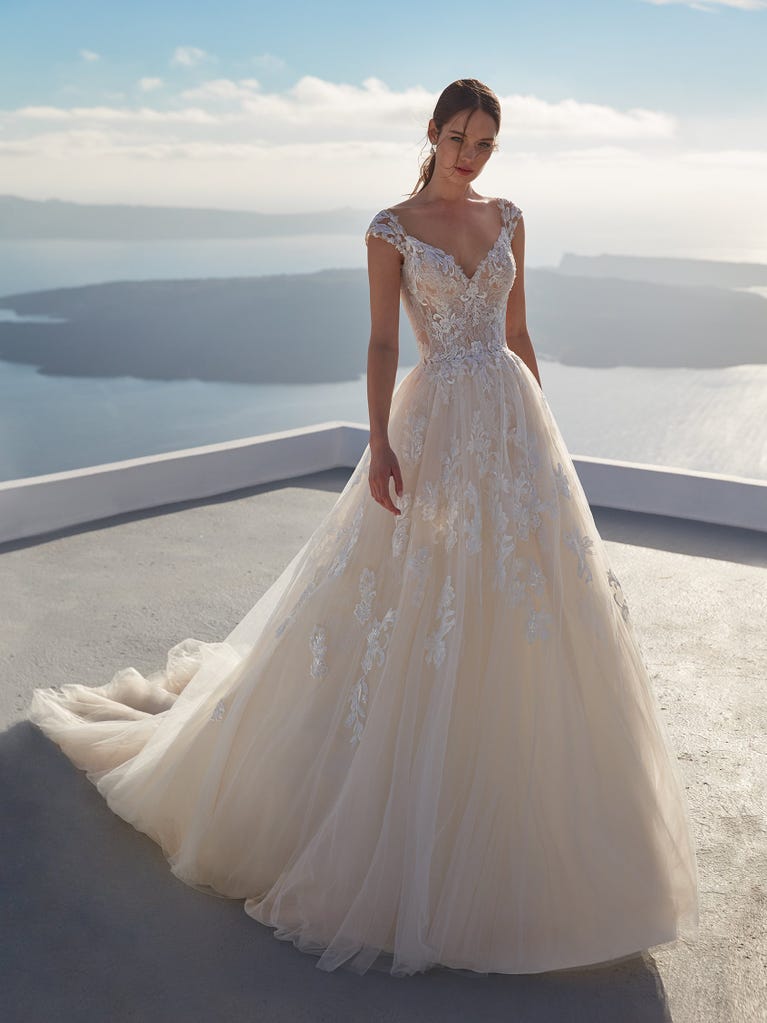 Tulle wedding dress with sleeveless bodice and sweetheart neckline. The embroidered lace creates a fabulous 3D effect, and the removable sleeves will look perfect during the ceremony.