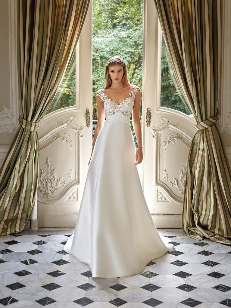 Tulle wedding dress with sleeveless bodice and sweetheart neckline. The embroidered lace creates a fabulous 3D effect, and the removable sleeves will look perfect during the ceremony.