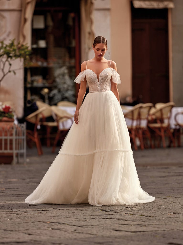 Tulle wedding dress with sleeveless bodice and sweetheart neckline. The embroidered lace creates a fabulous 3D effect, and the removable sleeves will look perfect during the ceremony.