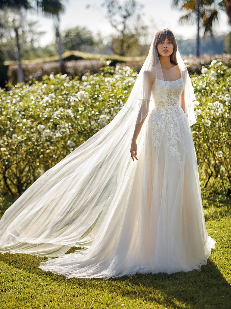 Flared wedding dress with voluminous yet lightweight tulle skirt with lace embroidered with floral motifs. For brides who dream of a romantic, feminine dress to say “I do.”