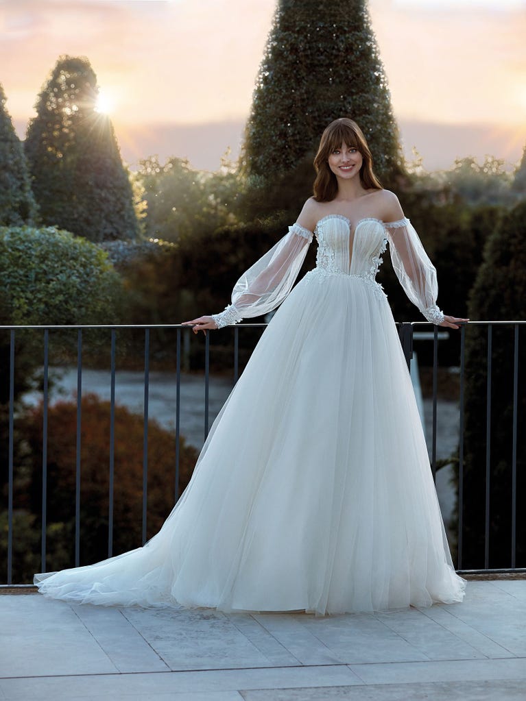 Tulle wedding dress with sleeveless bodice and sweetheart neckline. The embroidered lace creates a fabulous 3D effect, and the removable sleeves will look perfect during the ceremony.