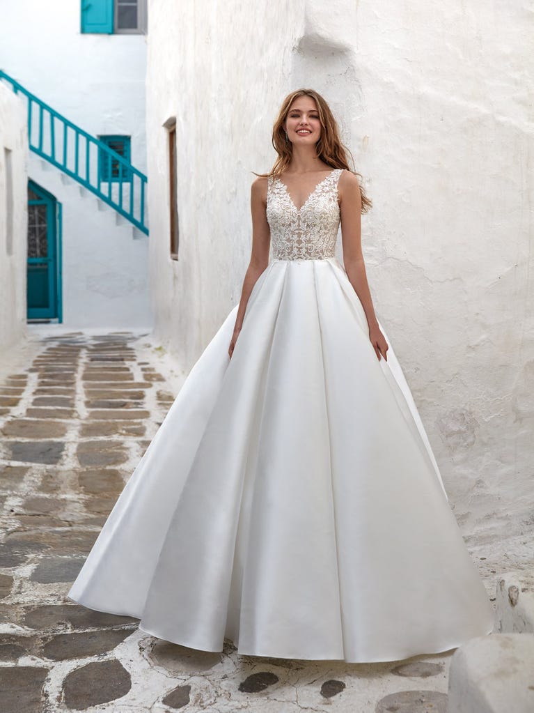 Tulle wedding dress with sleeveless bodice and sweetheart neckline. The embroidered lace creates a fabulous 3D effect, and the removable sleeves will look perfect during the ceremony.