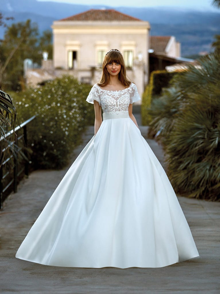 Tulle wedding dress with sleeveless bodice and sweetheart neckline. The embroidered lace creates a fabulous 3D effect, and the removable sleeves will look perfect during the ceremony.