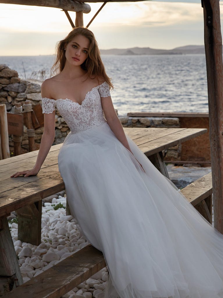 Tulle wedding dress with sleeveless bodice and sweetheart neckline. The embroidered lace creates a fabulous 3D effect, and the removable sleeves will look perfect during the ceremony.