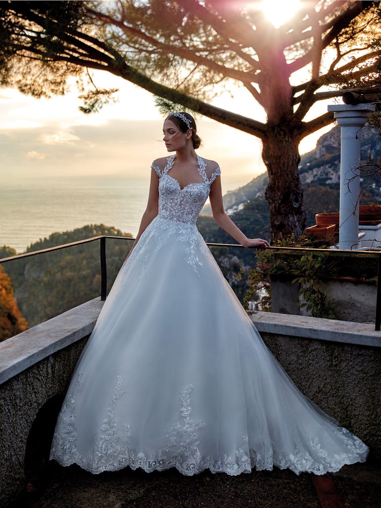 Tulle wedding dress with sleeveless bodice and sweetheart neckline. The embroidered lace creates a fabulous 3D effect, and the removable sleeves will look perfect during the ceremony.