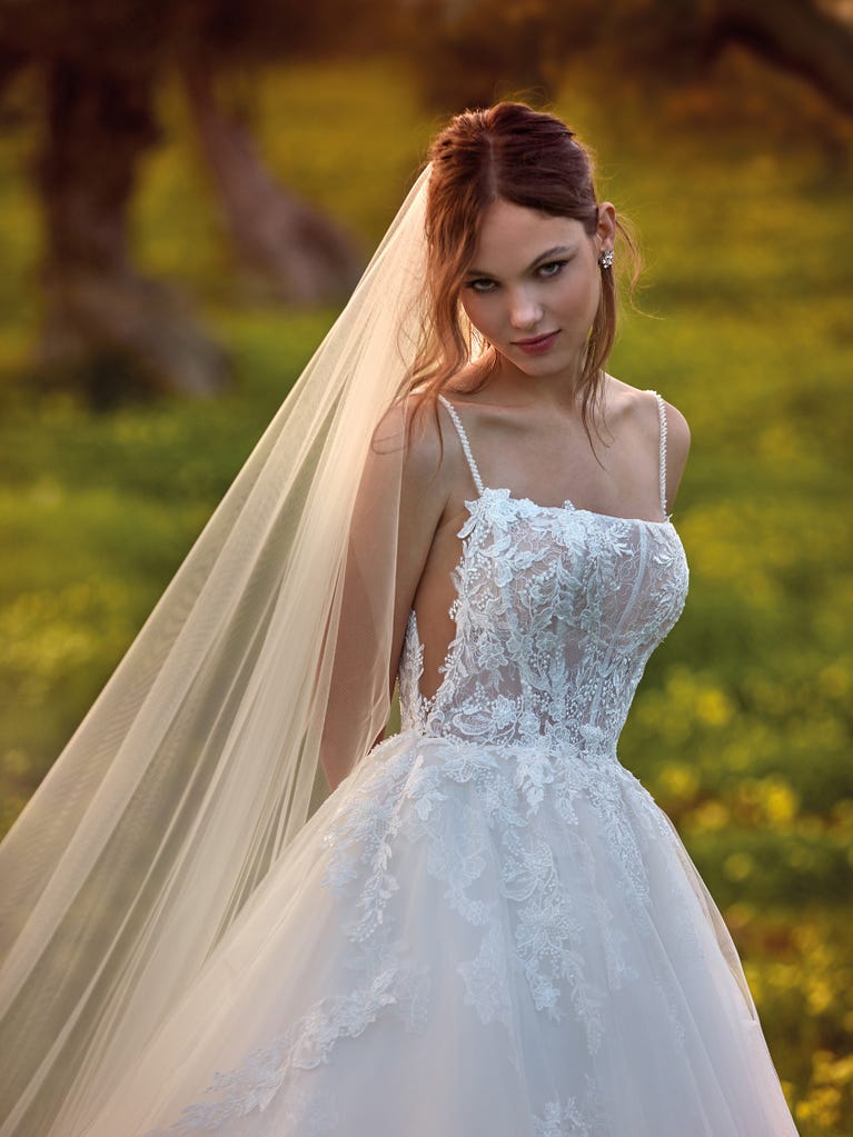 Tulle wedding dress with sleeveless bodice and sweetheart neckline. The embroidered lace creates a fabulous 3D effect, and the removable sleeves will look perfect during the ceremony.