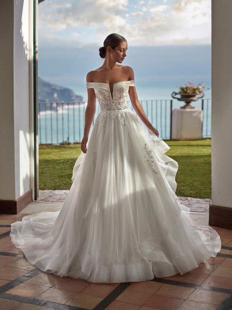 Tulle wedding dress with sleeveless bodice and sweetheart neckline. The embroidered lace creates a fabulous 3D effect, and the removable sleeves will look perfect during the ceremony.