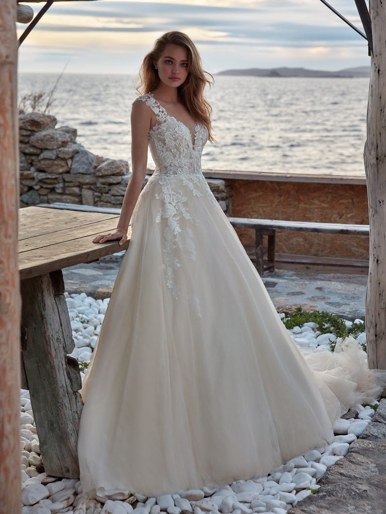 Tulle wedding dress with sleeveless bodice and sweetheart neckline. The embroidered lace creates a fabulous 3D effect, and the removable sleeves will look perfect during the ceremony.