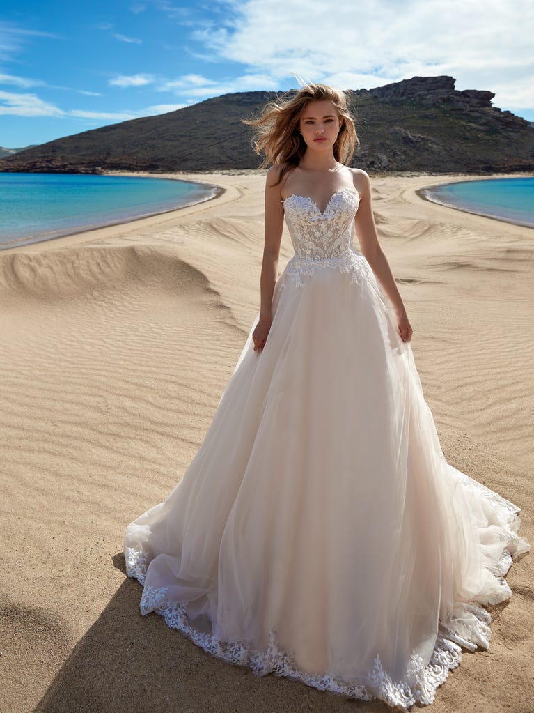 Tulle wedding dress with sleeveless bodice and sweetheart neckline. The embroidered lace creates a fabulous 3D effect, and the removable sleeves will look perfect during the ceremony.