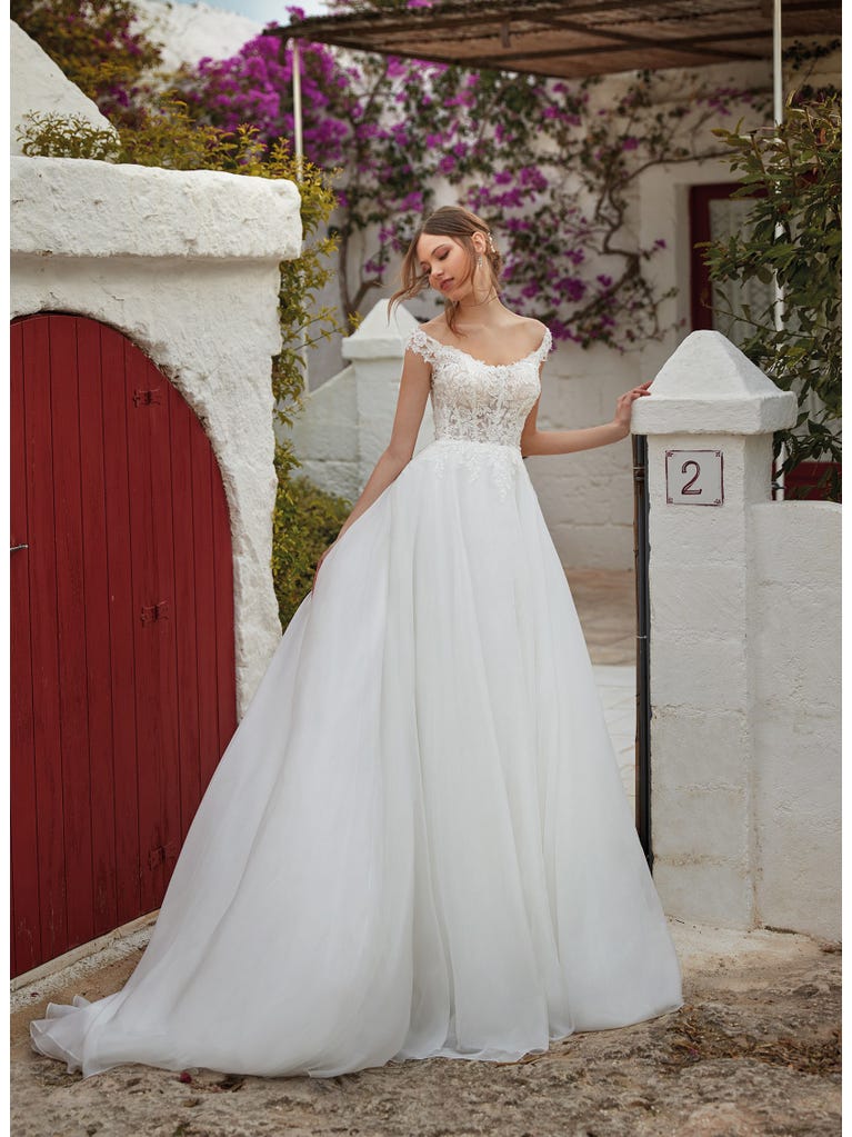 Flared wedding dress with voluminous yet lightweight tulle skirt with lace embroidered with floral motifs. For brides who dream of a romantic, feminine dress to say “I do.”