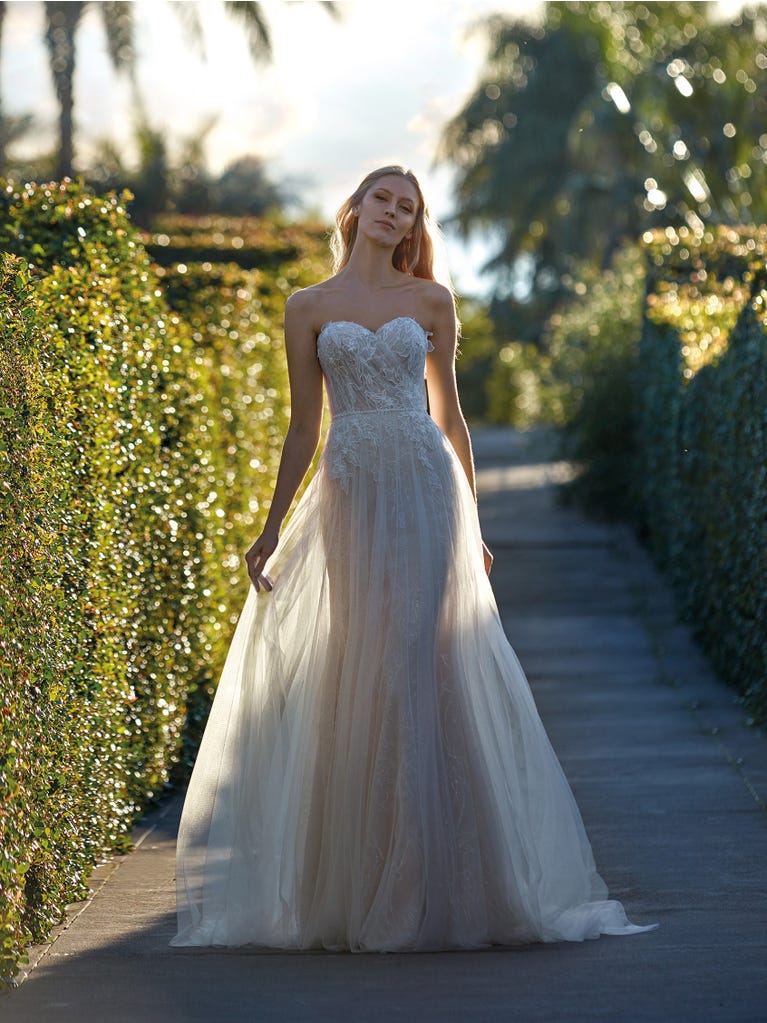 Flared wedding dress with voluminous yet lightweight tulle skirt with lace embroidered with floral motifs. For brides who dream of a romantic, feminine dress to say “I do.”