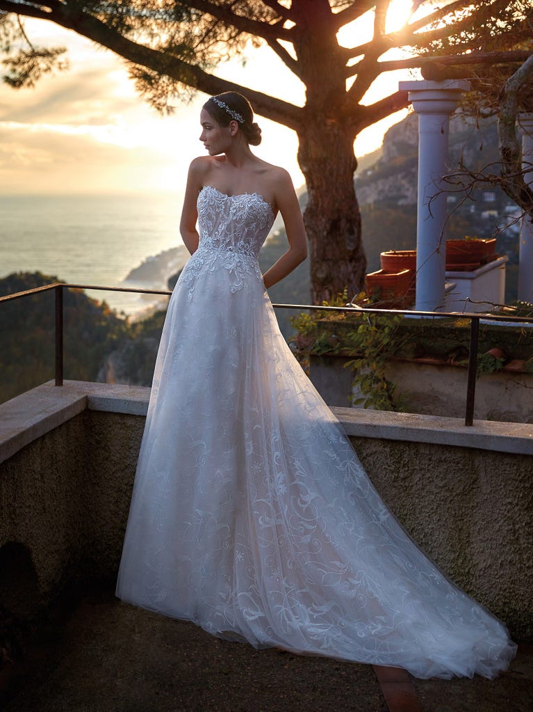 Flared wedding dress with voluminous yet lightweight tulle skirt with lace embroidered with floral motifs. For brides who dream of a romantic, feminine dress to say “I do.”