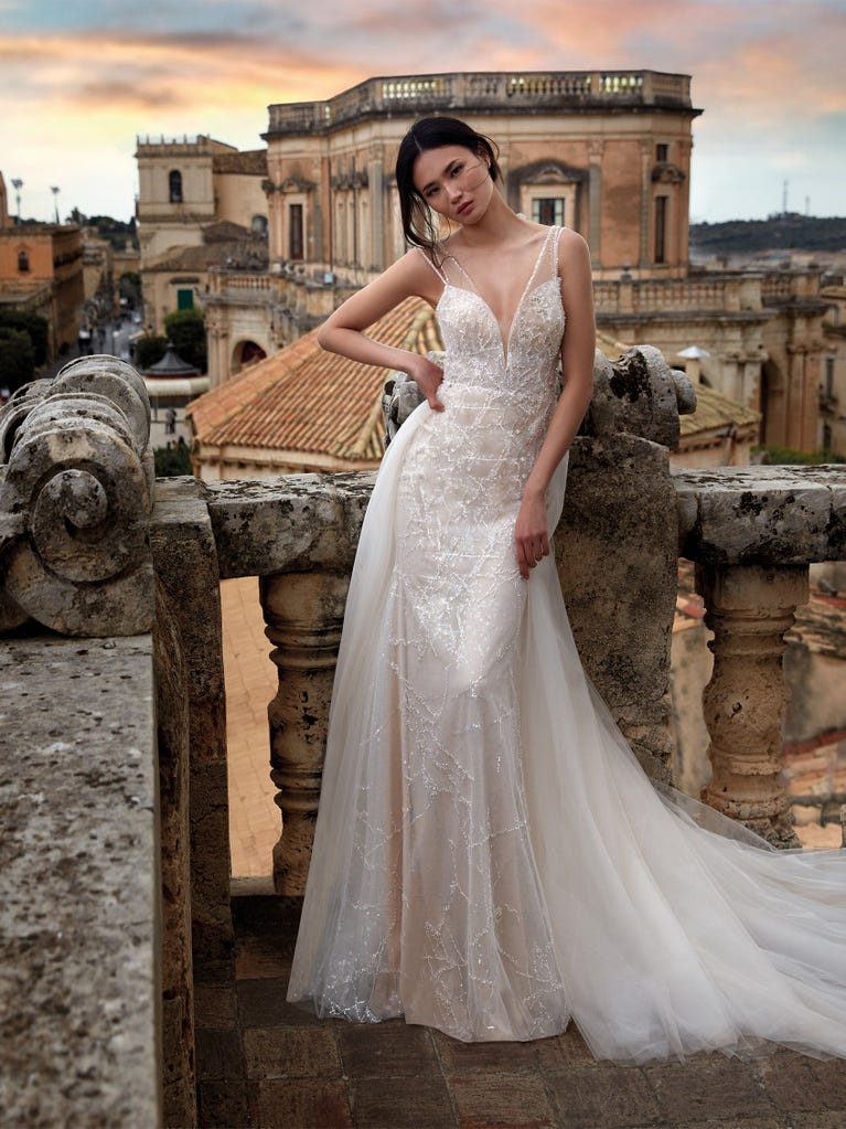 Princess wedding dress in carmine red tulle. The tulle ruffles create a light volume on the skirt and the sleeveless bodice, while the high waistline enhances the waist.