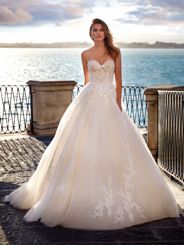 Tulle wedding dress with sleeveless bodice and sweetheart neckline. The embroidered lace creates a fabulous 3D effect, and the removable sleeves will look perfect during the ceremony.