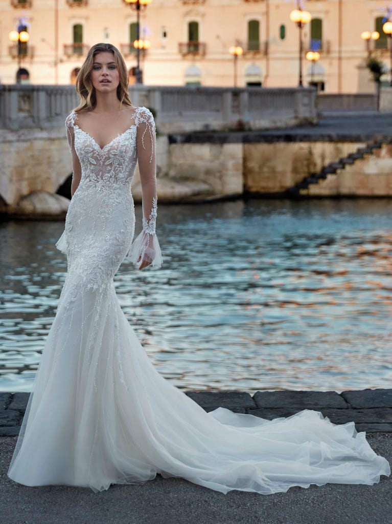 Princess wedding dress in carmine red tulle. The tulle ruffles create a light volume on the skirt and the sleeveless bodice, while the high waistline enhances the waist.