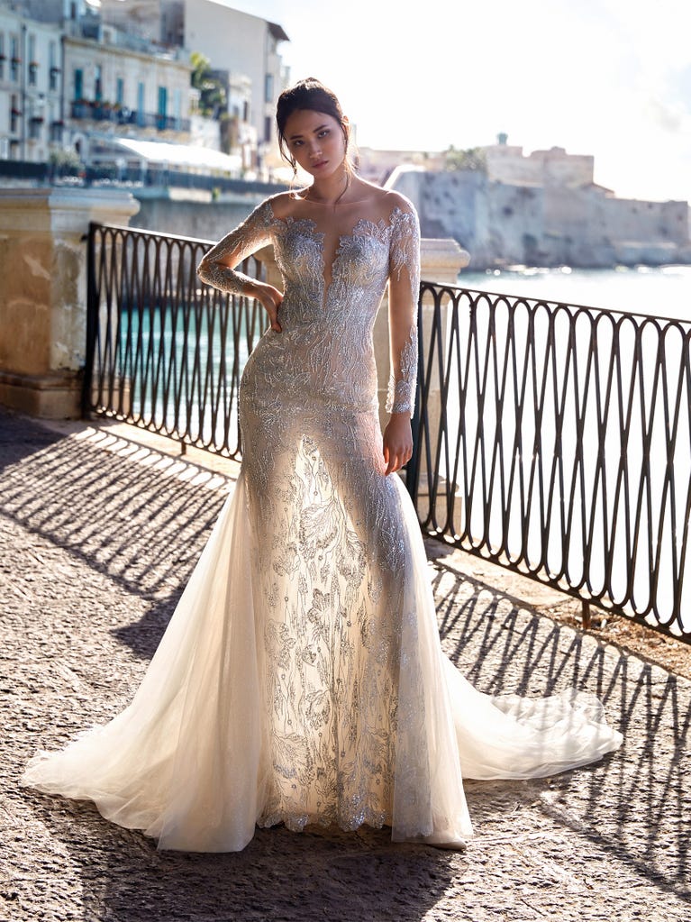 Princess wedding dress in carmine red tulle. The tulle ruffles create a light volume on the skirt and the sleeveless bodice, while the high waistline enhances the waist.