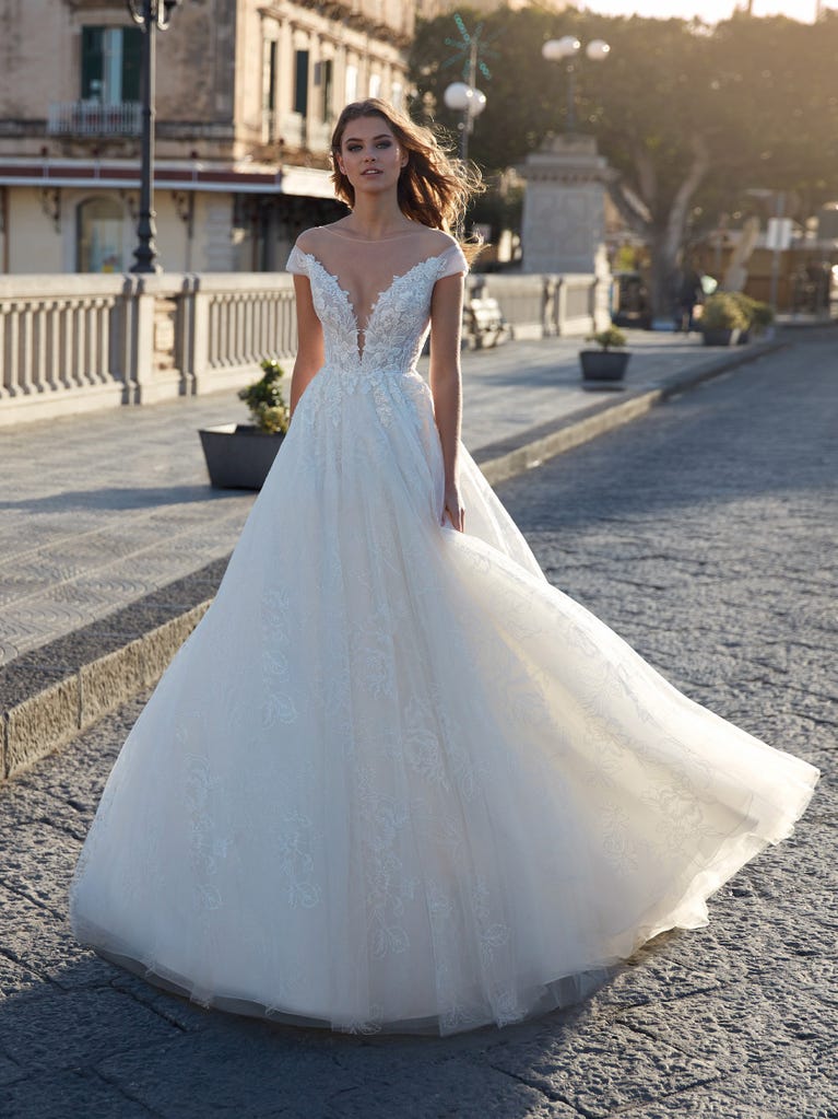 Tulle wedding dress with sleeveless bodice and sweetheart neckline. The embroidered lace creates a fabulous 3D effect, and the removable sleeves will look perfect during the ceremony.