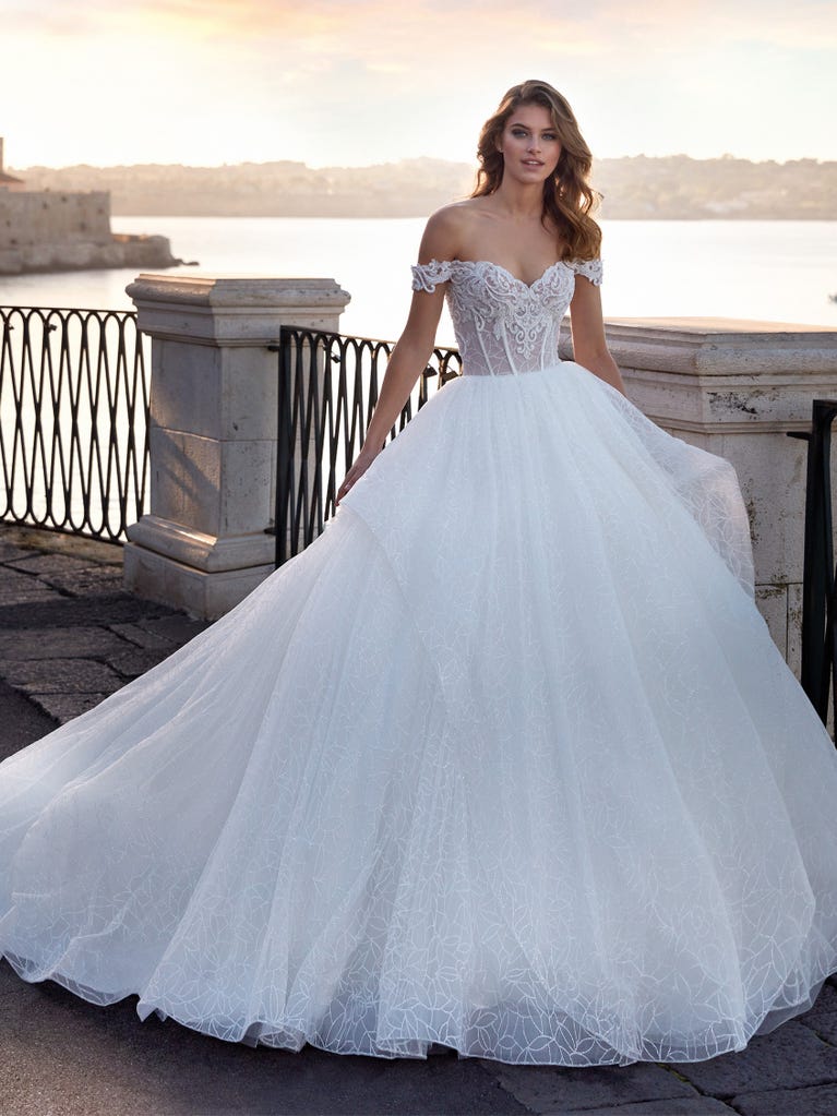 Tulle wedding dress with sleeveless bodice and sweetheart neckline. The embroidered lace creates a fabulous 3D effect, and the removable sleeves will look perfect during the ceremony.