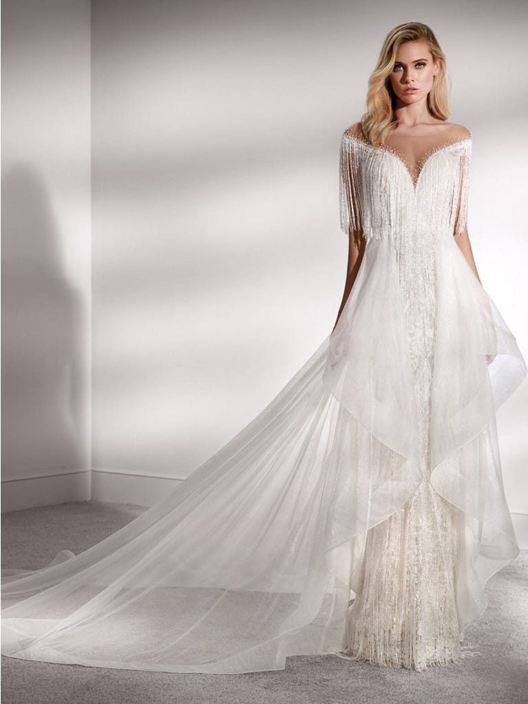 Princess wedding dress in carmine red tulle. The tulle ruffles create a light volume on the skirt and the sleeveless bodice, while the high waistline enhances the waist.