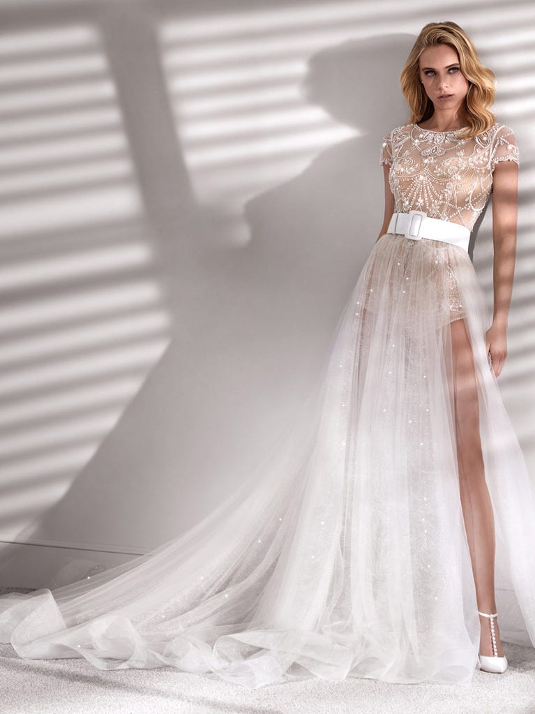 Princess wedding dress in carmine red tulle. The tulle ruffles create a light volume on the skirt and the sleeveless bodice, while the high waistline enhances the waist.