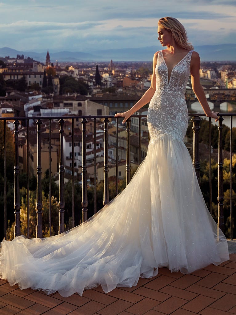Princess wedding dress in carmine red tulle. The tulle ruffles create a light volume on the skirt and the sleeveless bodice, while the high waistline enhances the waist.
