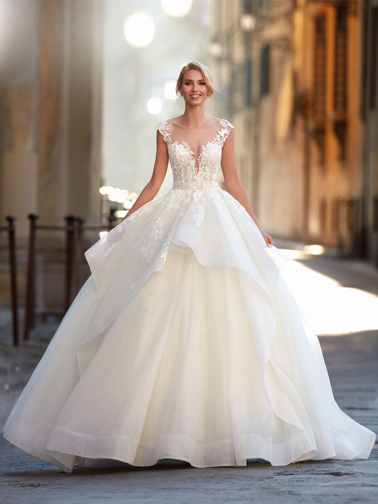 Princess wedding dress in carmine red tulle. The tulle ruffles create a light volume on the skirt and the sleeveless bodice, while the high waistline enhances the waist.
