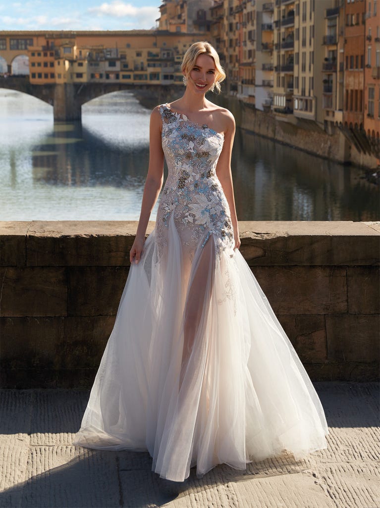 Princess wedding dress in carmine red tulle. The tulle ruffles create a light volume on the skirt and the sleeveless bodice, while the high waistline enhances the waist.