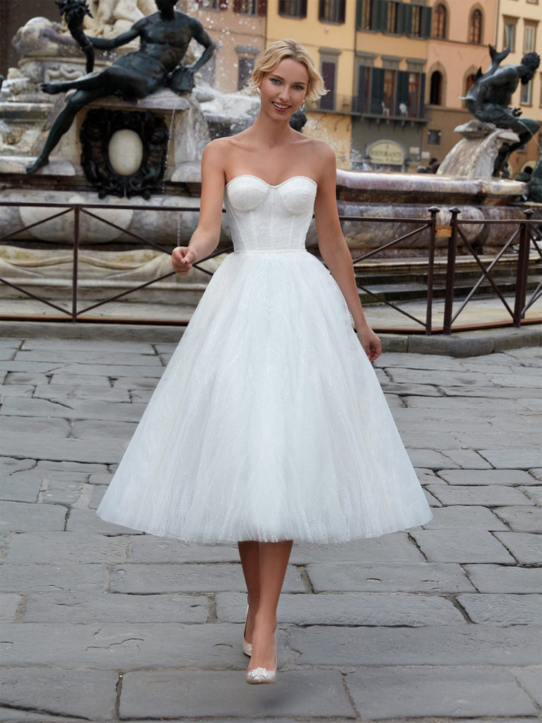 Princess wedding dress in carmine red tulle. The tulle ruffles create a light volume on the skirt and the sleeveless bodice, while the high waistline enhances the waist.