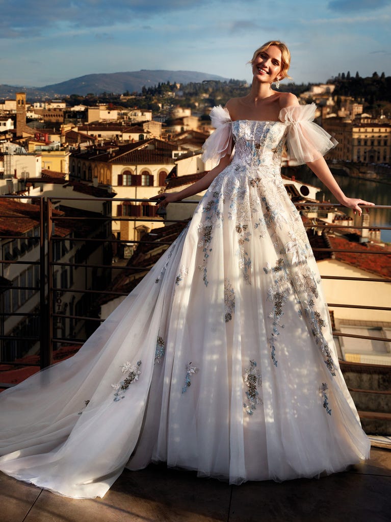 Princess wedding dress in carmine red tulle. The tulle ruffles create a light volume on the skirt and the sleeveless bodice, while the high waistline enhances the waist.