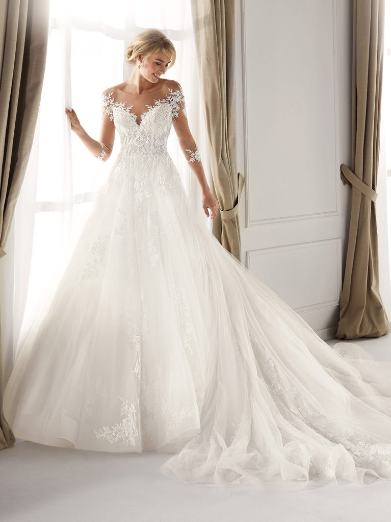 Fit & flare champagne tulle wedding dress with off-white guipure lace floral designs. The rounded neckline with tattoo-effect lace is highlighted with a refined, romantic 3D flower on the shoulder.