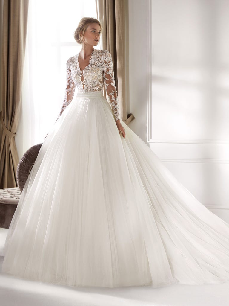 Fit & flare champagne tulle wedding dress with off-white guipure lace floral designs. The rounded neckline with tattoo-effect lace is highlighted with a refined, romantic 3D flower on the shoulder.