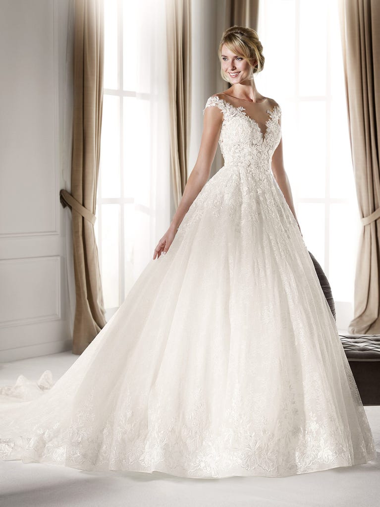 Fit & flare champagne tulle wedding dress with off-white guipure lace floral designs. The rounded neckline with tattoo-effect lace is highlighted with a refined, romantic 3D flower on the shoulder.