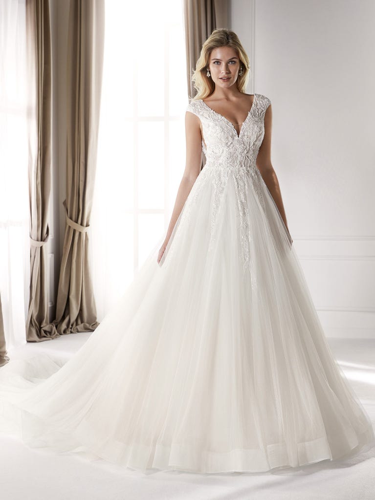 Fit & flare champagne tulle wedding dress with off-white guipure lace floral designs. The rounded neckline with tattoo-effect lace is highlighted with a refined, romantic 3D flower on the shoulder.