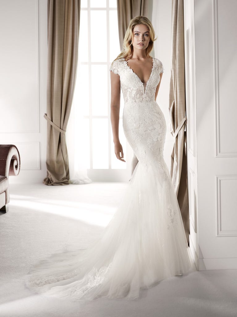 Fit & flare champagne tulle wedding dress with off-white guipure lace floral designs. The rounded neckline with tattoo-effect lace is highlighted with a refined, romantic 3D flower on the shoulder.