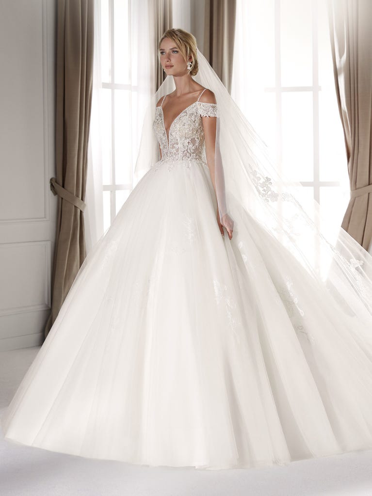 Fit & flare champagne tulle wedding dress with off-white guipure lace floral designs. The rounded neckline with tattoo-effect lace is highlighted with a refined, romantic 3D flower on the shoulder.
