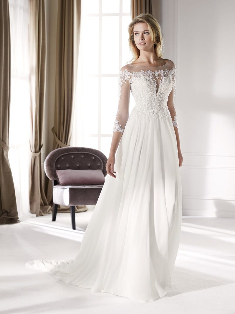 Fit & flare champagne tulle wedding dress with off-white guipure lace floral designs. The rounded neckline with tattoo-effect lace is highlighted with a refined, romantic 3D flower on the shoulder.