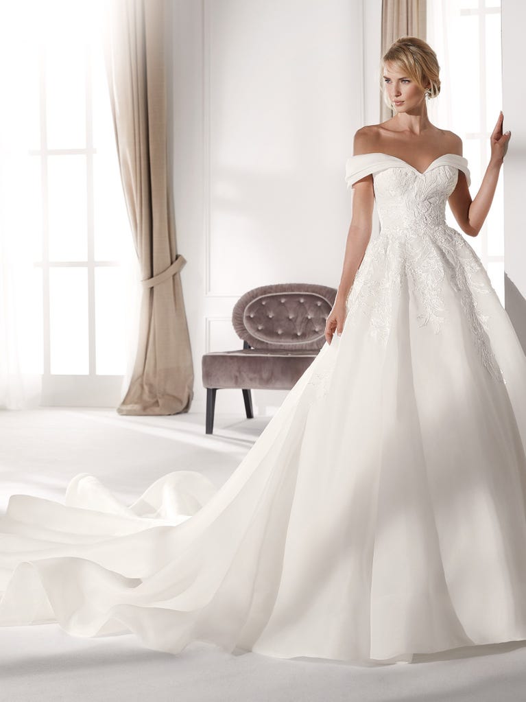 Fit & flare champagne tulle wedding dress with off-white guipure lace floral designs. The rounded neckline with tattoo-effect lace is highlighted with a refined, romantic 3D flower on the shoulder.