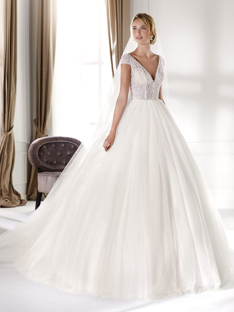 Fit & flare champagne tulle wedding dress with off-white guipure lace floral designs. The rounded neckline with tattoo-effect lace is highlighted with a refined, romantic 3D flower on the shoulder.