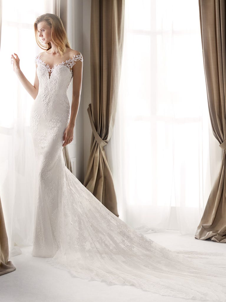 Fit & flare champagne tulle wedding dress with off-white guipure lace floral designs. The rounded neckline with tattoo-effect lace is highlighted with a refined, romantic 3D flower on the shoulder.