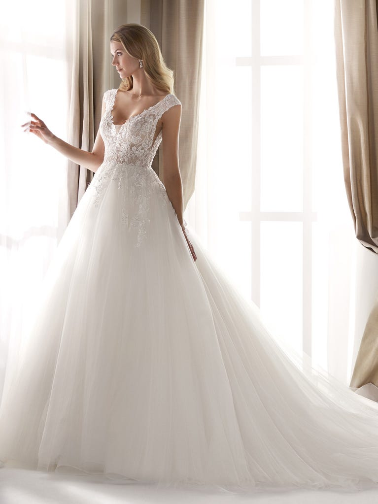 Fit & flare champagne tulle wedding dress with off-white guipure lace floral designs. The rounded neckline with tattoo-effect lace is highlighted with a refined, romantic 3D flower on the shoulder.