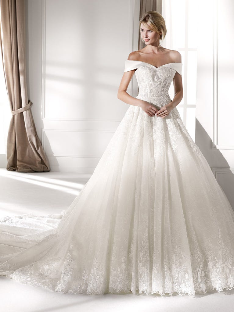 Fit & flare champagne tulle wedding dress with off-white guipure lace floral designs. The rounded neckline with tattoo-effect lace is highlighted with a refined, romantic 3D flower on the shoulder.
