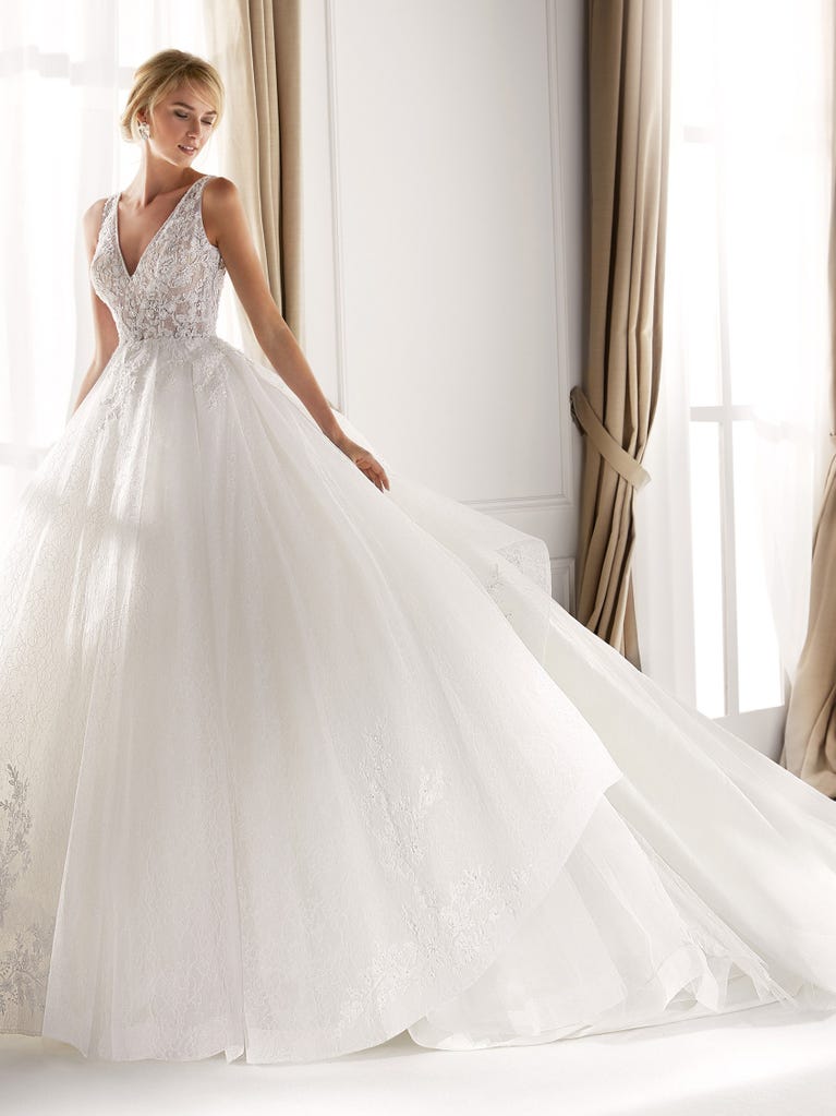 Fit & flare champagne tulle wedding dress with off-white guipure lace floral designs. The rounded neckline with tattoo-effect lace is highlighted with a refined, romantic 3D flower on the shoulder.