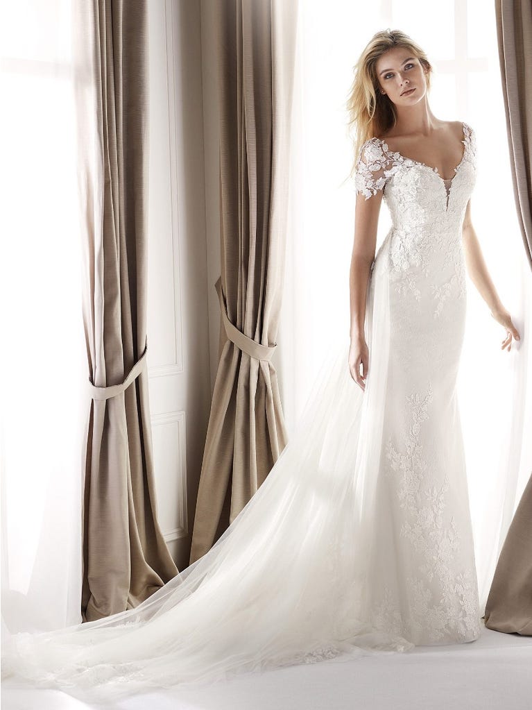 Fit & flare champagne tulle wedding dress with off-white guipure lace floral designs. The rounded neckline with tattoo-effect lace is highlighted with a refined, romantic 3D flower on the shoulder.